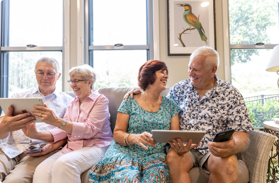 Residents sharing tablets together on a couch